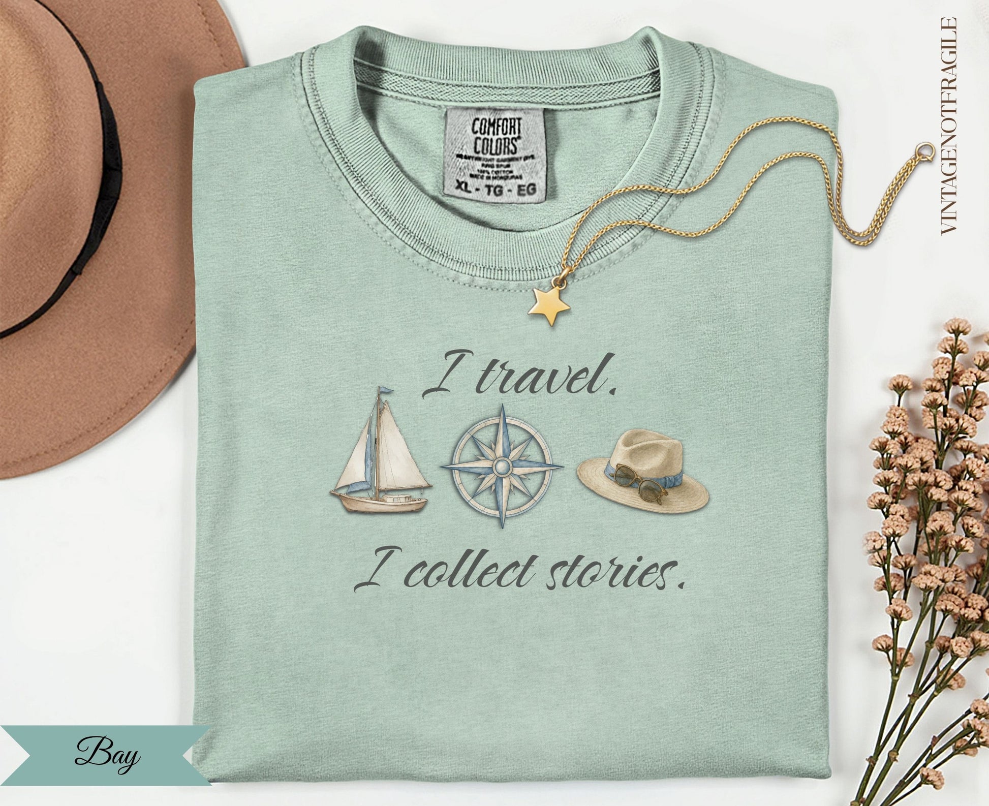 Pale green t-shirt with "I travel. I collect stories." and nautical illustrations.